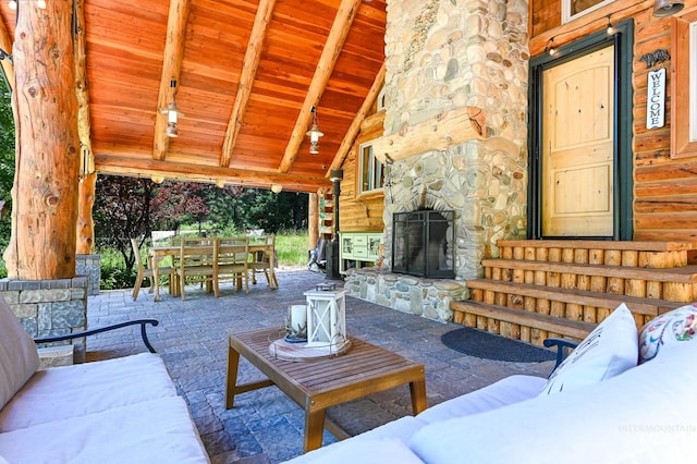 view of patio with outdoor dining space, an outdoor living space with a fireplace, and entry steps