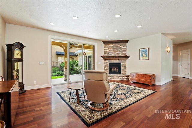 12970 N 9th Ave, Boise, ID 83714 - living area with a textured ceiling, a stone fireplace, wood finished floors, baseboards, and recessed lighting