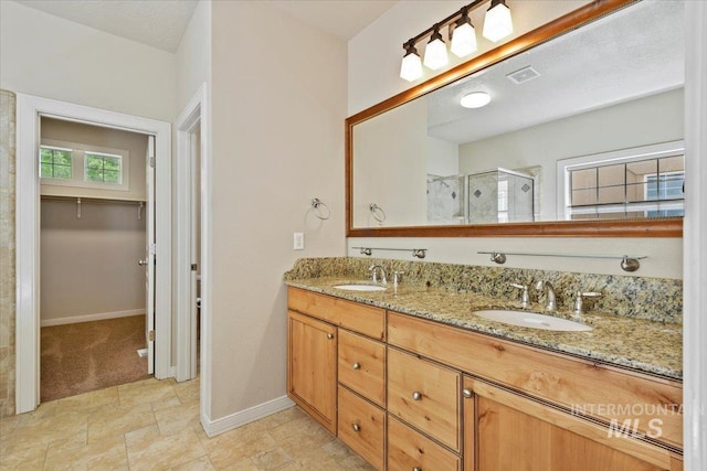 12970 N 9th Ave, Boise, ID 83714 - full bathroom featuring a stall shower, baseboards, double vanity, a walk in closet, and stone finish flooring