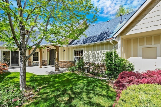 12970 N 9th Ave, Boise, ID 83714 - rear view of house featuring board and batten siding, roof with shingles, a yard, and a patio area