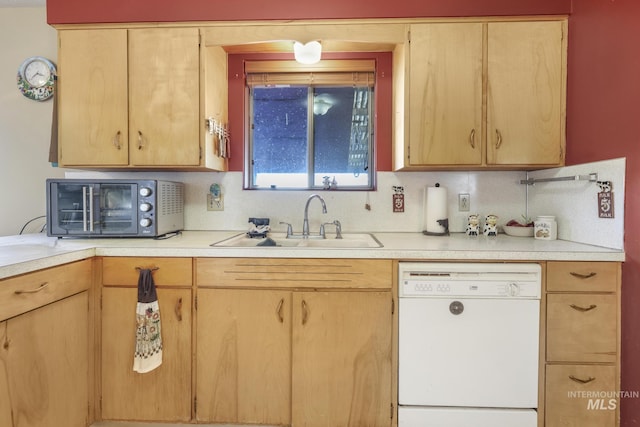 kitchen featuring white dishwasher and light brown cabinetry