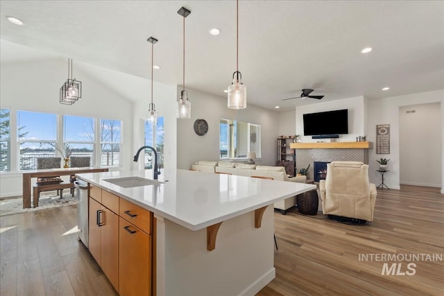 8237 W Corinthia St, Eagle, ID 83616 - kitchen featuring recessed lighting, light wood finished floors, a tiled fireplace, ceiling fan, and an island with sink