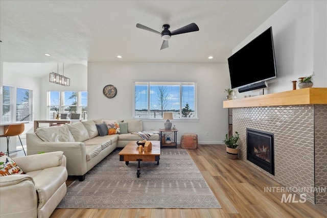 8237 W Corinthia St, Eagle, ID 83616 - living room featuring wood finished floors, a tile fireplace, a ceiling fan, and recessed lighting