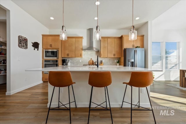 8237 W Corinthia St, Eagle, ID 83616 - kitchen with stainless steel appliances, wall chimney range hood, light countertops, a kitchen island with sink, and backsplash