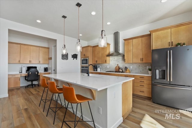 8237 W Corinthia St, Eagle, ID 83616 - kitchen with appliances with stainless steel finishes, wall chimney exhaust hood, built in study area, tasteful backsplash, and wood finished floors
