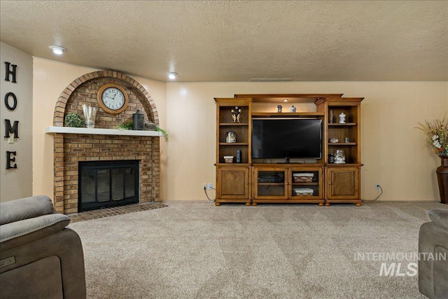 carpeted living room with a fireplace and a textured ceiling