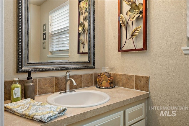 bathroom with a textured wall and vanity