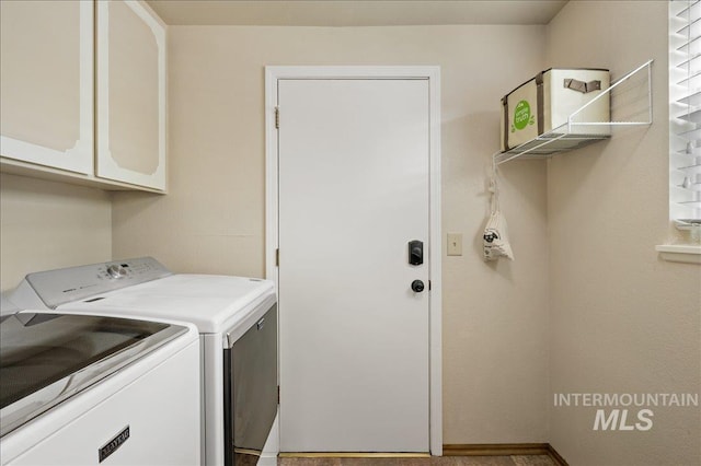 washroom with cabinet space and washer and clothes dryer