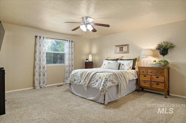 bedroom with a textured ceiling, ceiling fan, carpet flooring, and baseboards