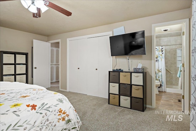 carpeted bedroom featuring a textured ceiling, a closet, and a ceiling fan