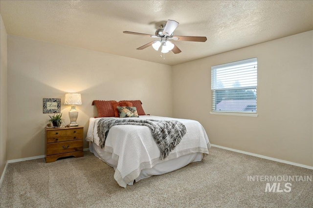 carpeted bedroom featuring a ceiling fan, a textured ceiling, and baseboards