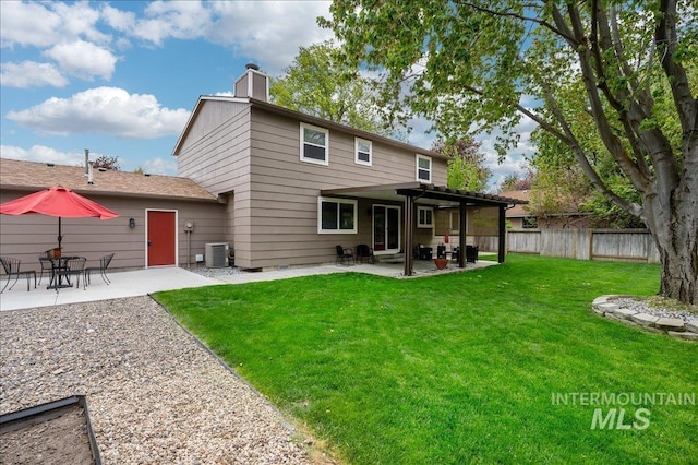 back of property with a patio, cooling unit, fence, a yard, and a chimney