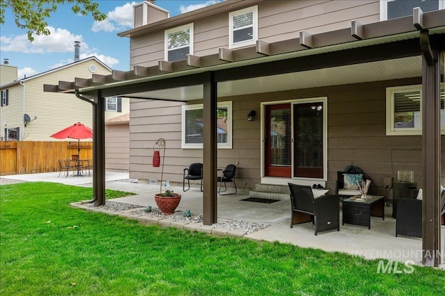 back of house featuring a yard, a chimney, fence, and a patio