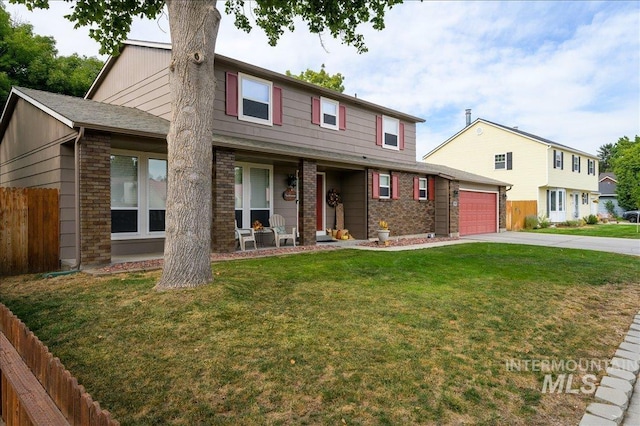 view of front of home featuring a front yard, fence, concrete driveway, and brick siding