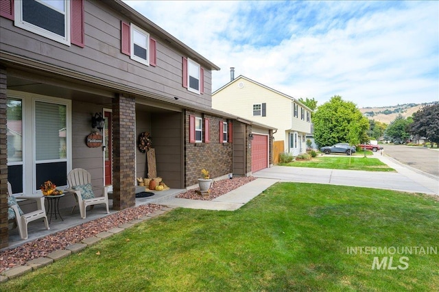 view of front facade featuring a garage, driveway, brick siding, and a front yard