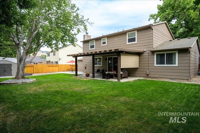 rear view of property featuring a chimney, a lawn, a patio area, fence, and a pergola