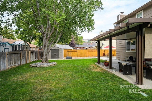 view of yard featuring an outbuilding, a patio, a shed, and a fenced backyard