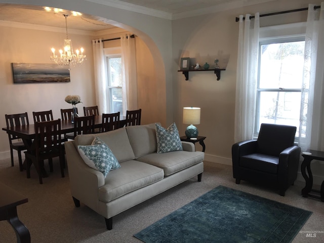 carpeted living room with a notable chandelier, a healthy amount of sunlight, and ornamental molding