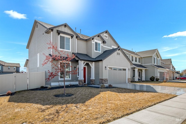 craftsman-style home with a front lawn, a gate, fence, board and batten siding, and concrete driveway