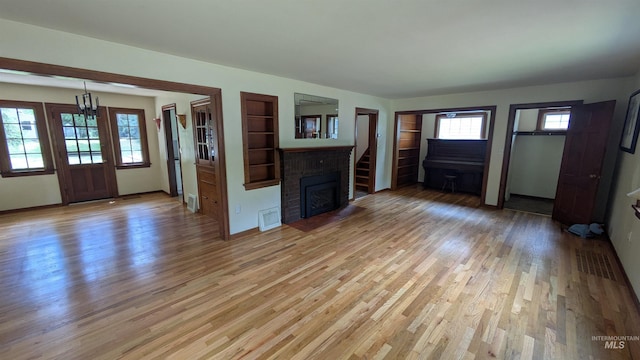 815 E 6th, Moscow, ID 83843 - unfurnished living room with light wood-style flooring and a fireplace