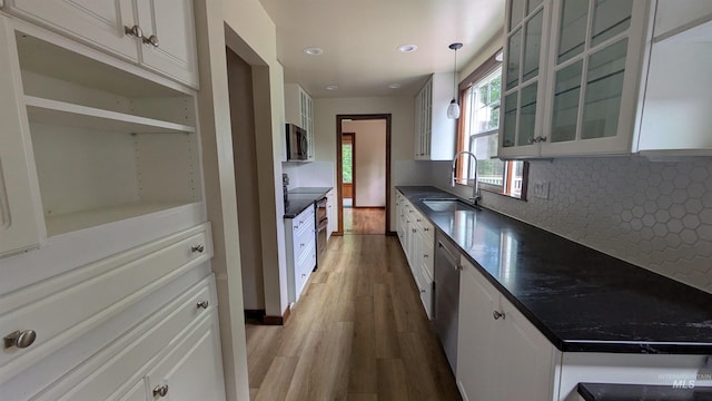 815 E 6th, Moscow, ID 83843 - kitchen with appliances with stainless steel finishes, dark countertops, wood finished floors, backsplash, and glass insert cabinets