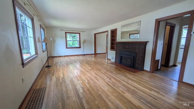 815 E 6th, Moscow, ID 83843 - unfurnished living room featuring wood finished floors and a fireplace