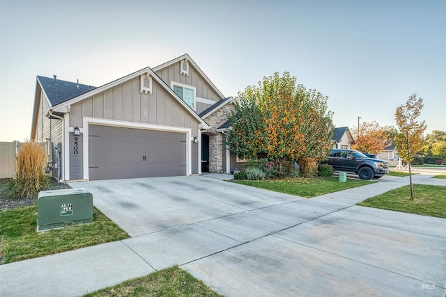craftsman-style house featuring concrete driveway, a garage, stone siding, and board and batten siding