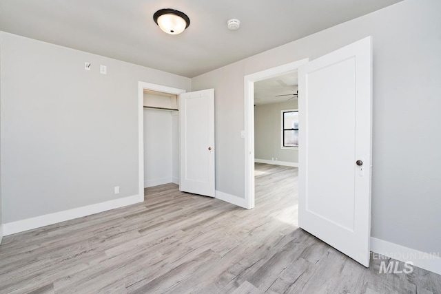 unfurnished bedroom featuring light wood-type flooring and a closet