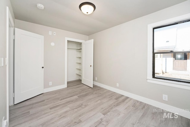 unfurnished bedroom with a closet and light hardwood / wood-style flooring