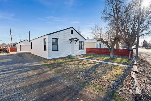 view of front of home featuring a garage and an outbuilding