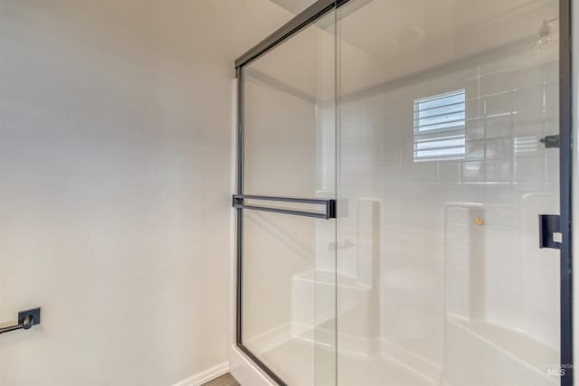 full bath with a stall shower and baseboards