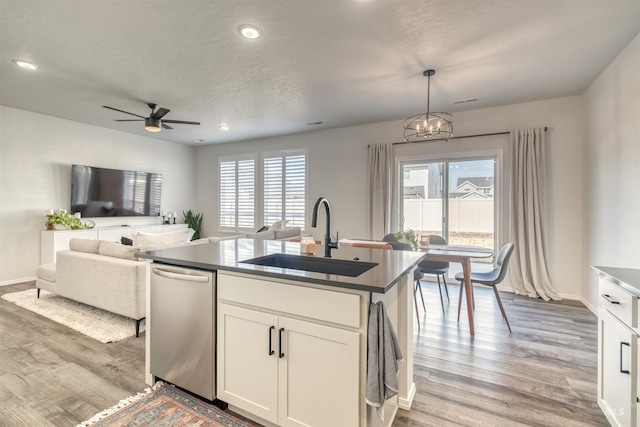 kitchen featuring a sink, dishwasher, light wood-style floors, white cabinetry, and recessed lighting