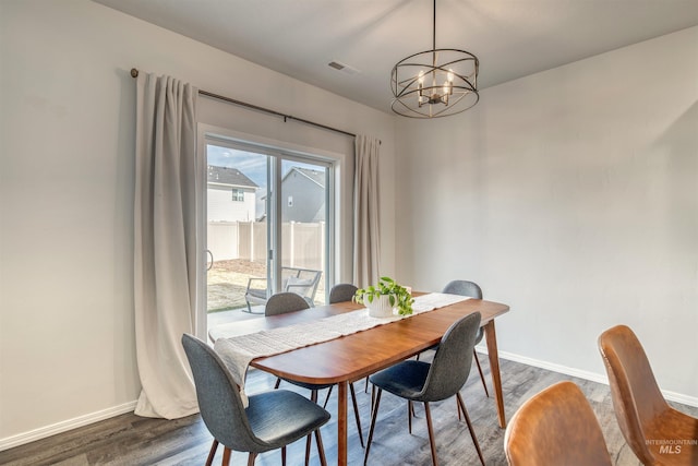 dining room featuring a chandelier, baseboards, and dark wood-style floors