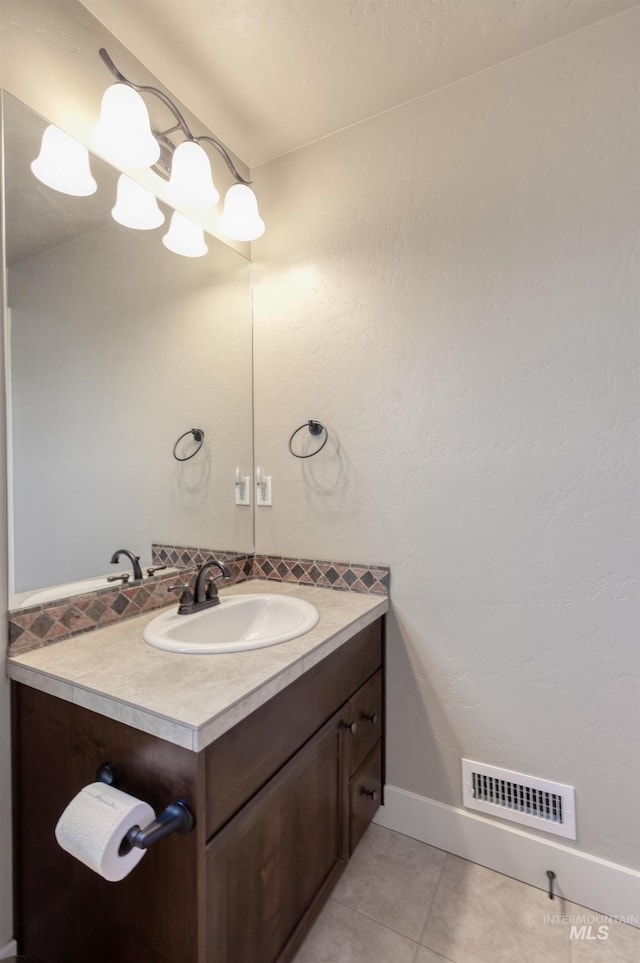13569 Paoletti St, Caldwell, ID 83607 - bathroom with vanity, tile patterned flooring, and backsplash
