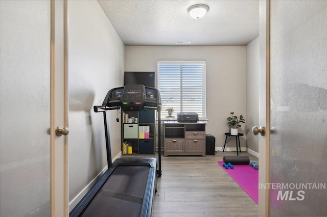1046 N Warm River Ave, Kuna, ID 83634 - exercise room with light wood-type flooring, a textured ceiling, visible vents, french doors, and baseboards