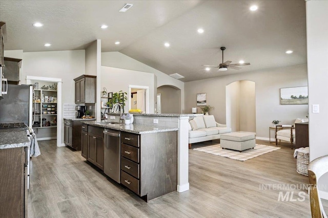 1046 N Warm River Ave, Kuna, ID 83634 - kitchen with dark brown cabinets, ceiling fan, stainless steel appliances, arched walkways, and a sink