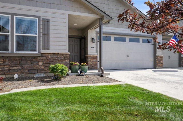 1046 N Warm River Ave, Kuna, ID 83634 - doorway to property with stone siding, a garage, and driveway