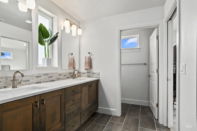 10110 Irongate Dr, Nampa, ID 83687 - full bathroom with double vanity, tasteful backsplash, baseboards, and a sink