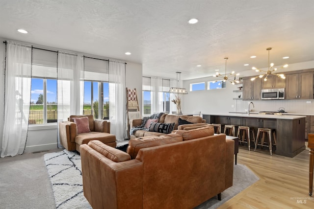 10110 Irongate Dr, Nampa, ID 83687 - living room with light wood-style flooring, a chandelier, and recessed lighting