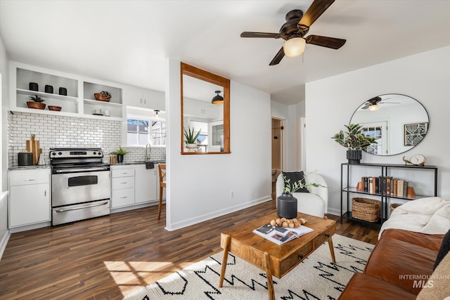 living room featuring baseboards, dark wood finished floors, and a ceiling fan