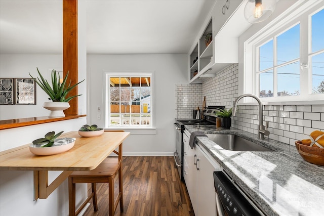 kitchen with backsplash, dark wood finished floors, stone counters, electric stove, and a sink