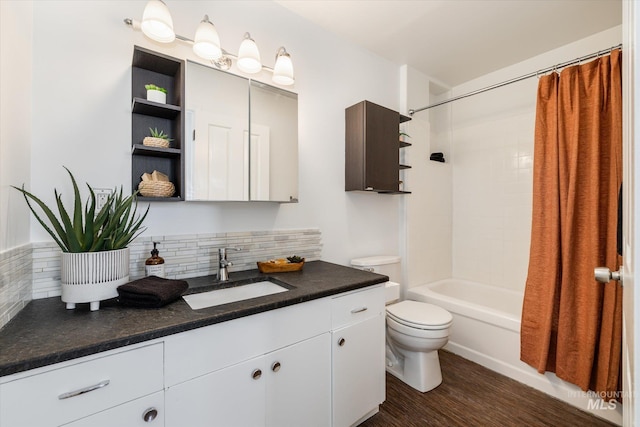 full bath featuring toilet, backsplash, wood finished floors, shower / tub combo, and vanity