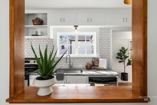 kitchen with dishwasher, tasteful backsplash, white cabinetry, and a sink