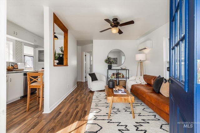 living area featuring a wall mounted air conditioner, baseboards, wood finished floors, and a ceiling fan