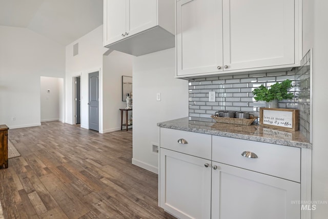 kitchen featuring light stone countertops, white cabinets, and dark hardwood / wood-style floors