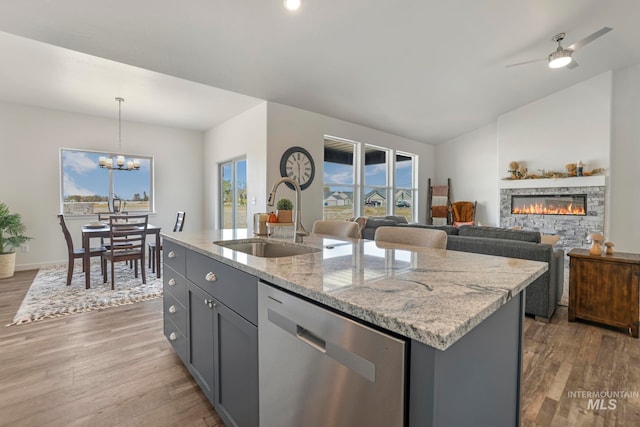 kitchen featuring dishwasher, a wealth of natural light, hanging light fixtures, and a kitchen island with sink