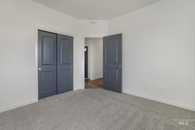 unfurnished bedroom featuring a closet and dark carpet