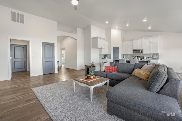 living room with ceiling fan, dark hardwood / wood-style flooring, and high vaulted ceiling