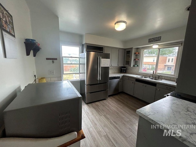 1527 13th Ave, Lewiston, ID 83501 - kitchen featuring appliances with stainless steel finishes, backsplash, light wood-style floors, open shelves, and light countertops