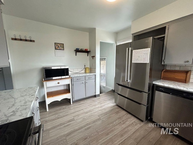 1527 13th Ave, Lewiston, ID 83501 - kitchen with stainless steel appliances, light wood-type flooring, open shelves, and light stone countertops